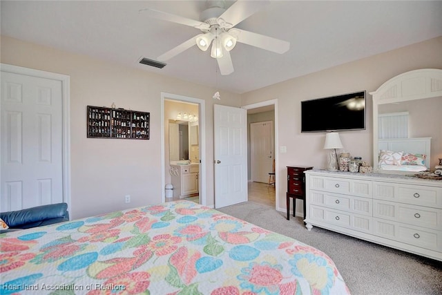 bedroom featuring ceiling fan, light colored carpet, and connected bathroom