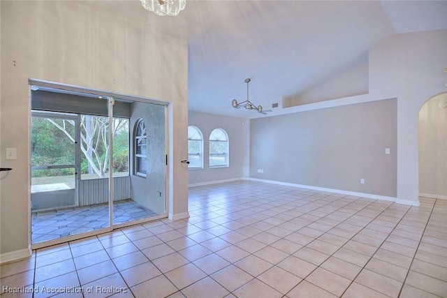 unfurnished room with high vaulted ceiling, a chandelier, and light tile patterned flooring