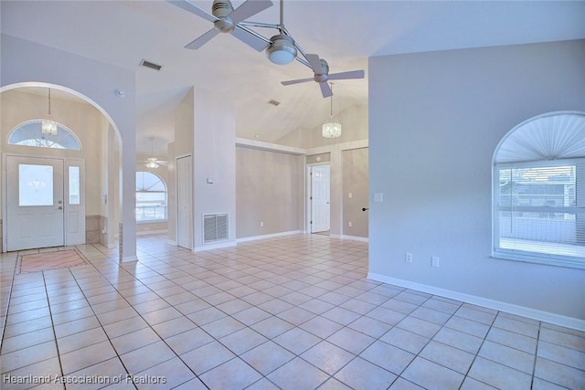 interior space featuring ceiling fan with notable chandelier, light tile patterned floors, and high vaulted ceiling