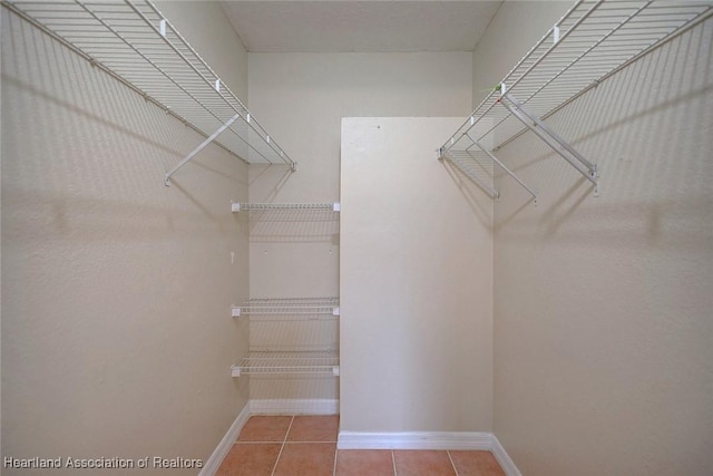 walk in closet with tile patterned floors