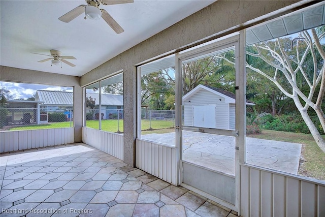 unfurnished sunroom featuring plenty of natural light and ceiling fan