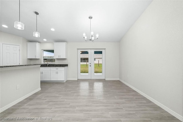 4818 Sturgeon Dr, Sebring, FL 33870 - kitchen featuring a sink, baseboards, white cabinets, hanging light fixtures, and french doors