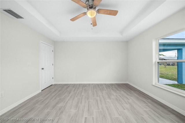 4818 Sturgeon Dr, Sebring, FL 33870 - spare room featuring a tray ceiling, wood tiled floor, visible vents, and baseboards