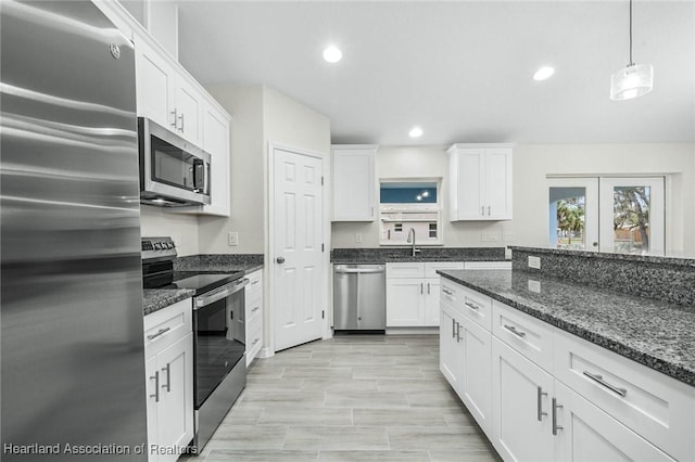 4818 Sturgeon Dr, Sebring, FL 33870 - kitchen with recessed lighting, appliances with stainless steel finishes, white cabinets, a sink, and dark stone counters