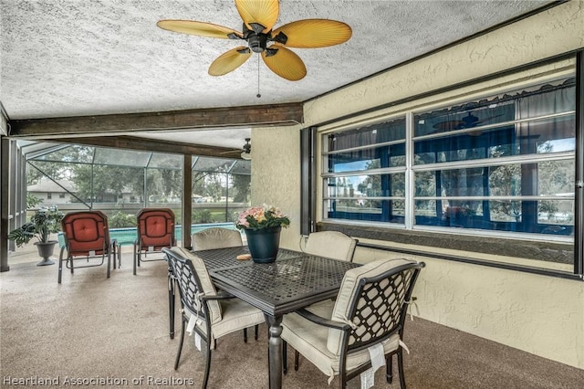 sunroom with ceiling fan, a healthy amount of sunlight, and beam ceiling