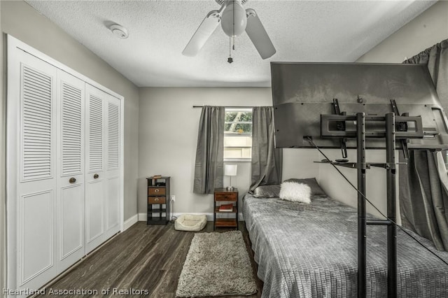 bedroom featuring a textured ceiling, a closet, ceiling fan, and dark wood-type flooring