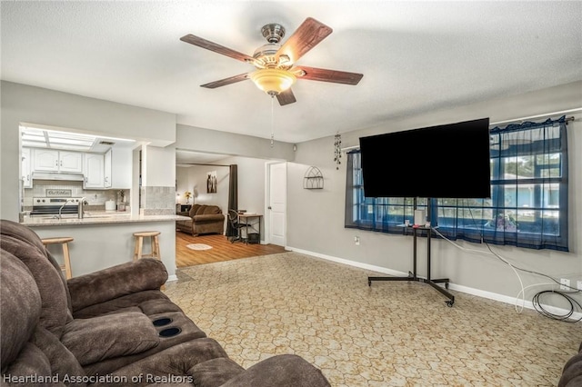 living room featuring a textured ceiling and ceiling fan