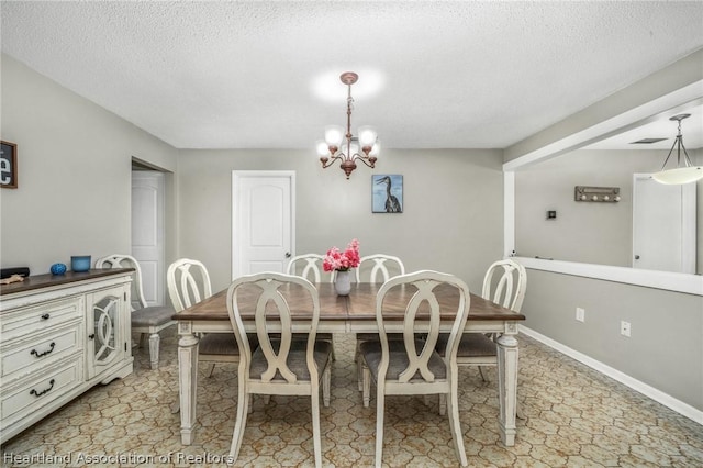 dining room featuring a notable chandelier and a textured ceiling