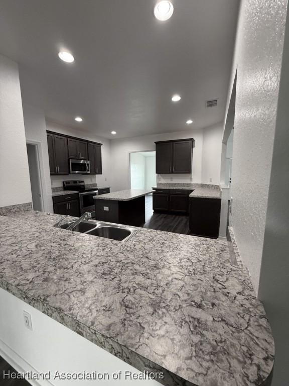 525 Central Ln, Frostproof, FL 33843 - kitchen featuring stainless steel appliances, a sink, recessed lighting, a kitchen island, and a peninsula