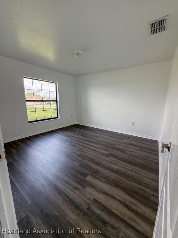 525 Central Ln, Frostproof, FL 33843 - spare room with dark wood-style flooring and baseboards