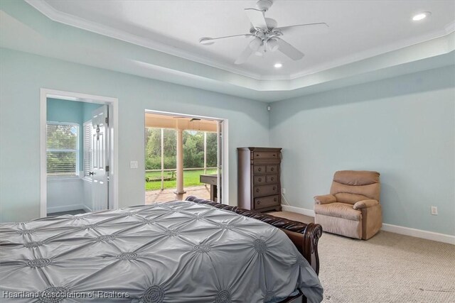 bedroom featuring a raised ceiling, multiple windows, access to outside, and carpet floors