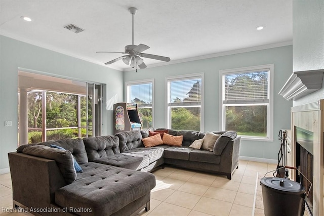 tiled living room with ceiling fan and crown molding