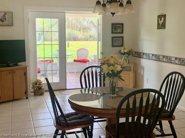 tiled dining area featuring a notable chandelier