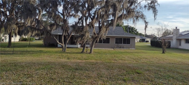 rear view of property featuring a lawn