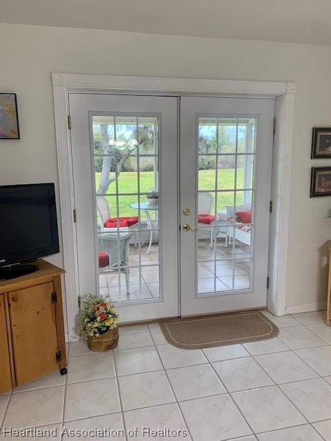 doorway to outside with french doors and light tile patterned flooring