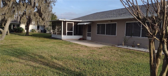 back of house featuring a sunroom and a yard