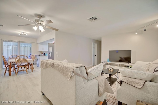 living room with ceiling fan, light wood-type flooring, and rail lighting