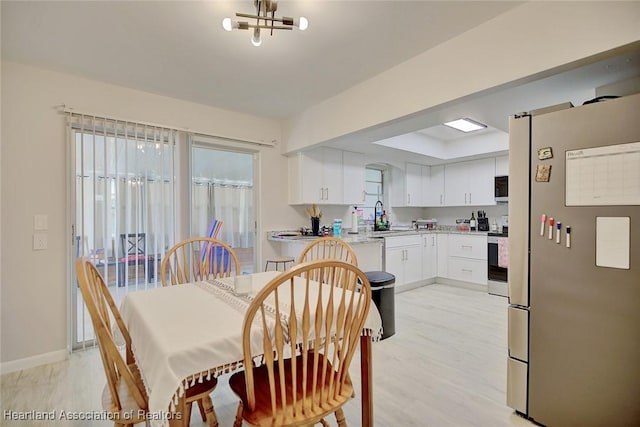 dining space with sink and light hardwood / wood-style flooring