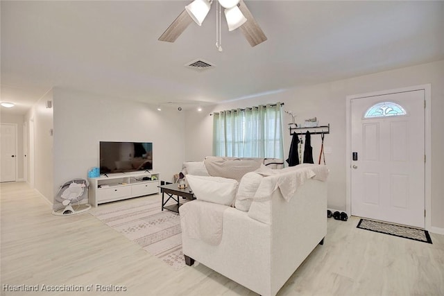 living room featuring ceiling fan and light hardwood / wood-style flooring