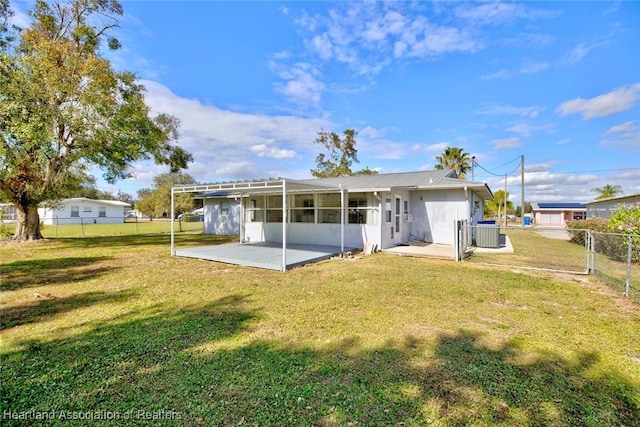 rear view of house featuring a lawn, a patio area, and central AC