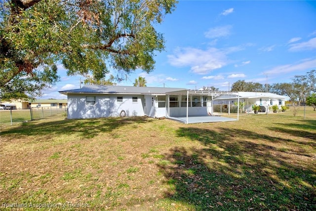 back of property featuring a lawn and a patio