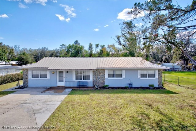 ranch-style home featuring covered porch and a front lawn