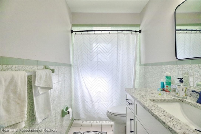 bathroom featuring vanity, tile patterned floors, a shower with curtain, toilet, and tile walls