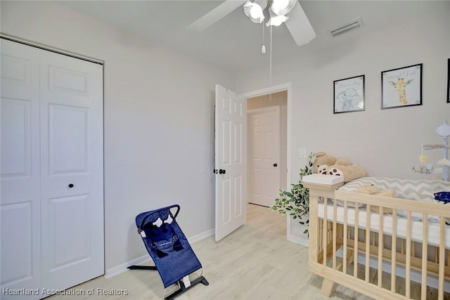 bedroom with ceiling fan, a closet, and a nursery area