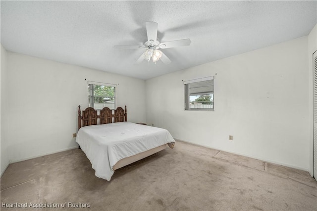 bedroom featuring carpet, a textured ceiling, and ceiling fan