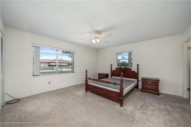 carpeted bedroom with multiple windows, a closet, and ceiling fan