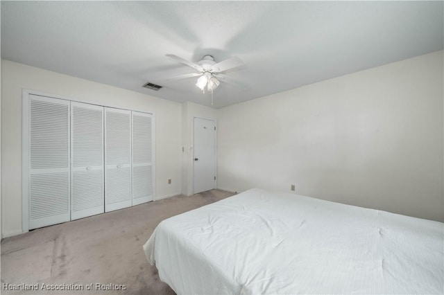 bedroom with light carpet, a closet, and ceiling fan