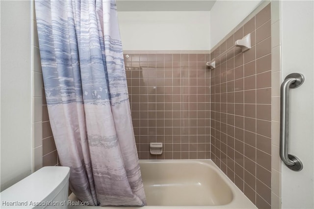 bathroom featuring shower / tub combo and toilet