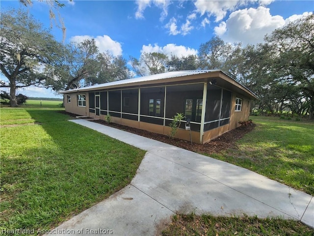 view of property exterior featuring a yard and a sunroom