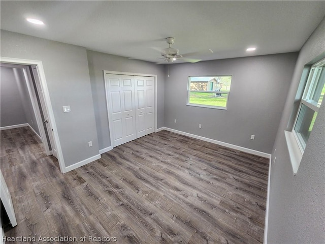 unfurnished bedroom featuring hardwood / wood-style flooring, ceiling fan, and a closet