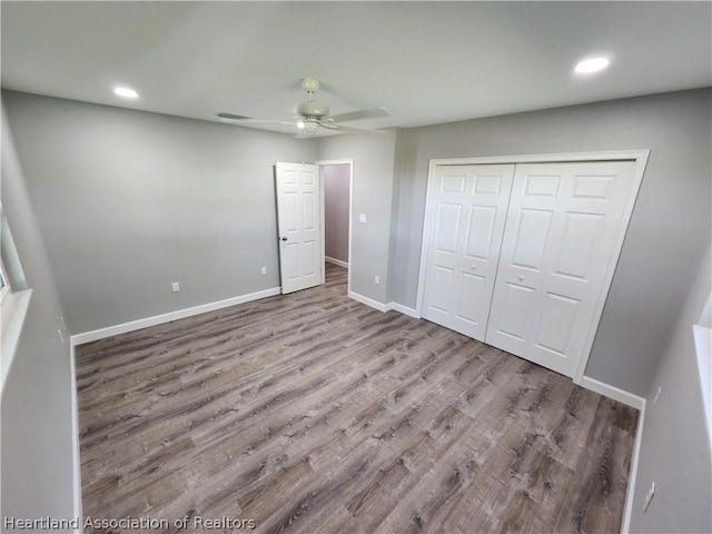 unfurnished bedroom featuring ceiling fan, a closet, and light hardwood / wood-style floors