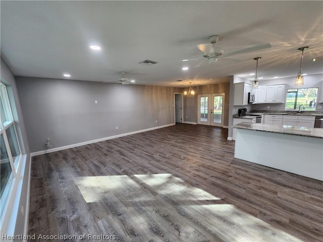 kitchen featuring dark hardwood / wood-style flooring, stainless steel appliances, ceiling fan, white cabinets, and hanging light fixtures