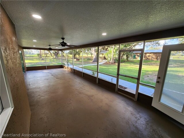 unfurnished sunroom with ceiling fan