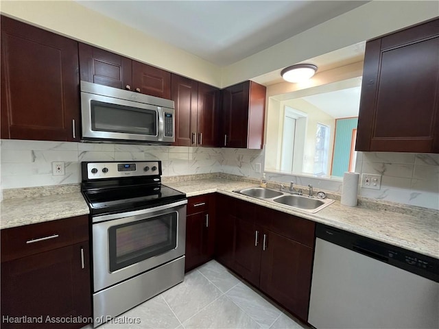 kitchen featuring decorative backsplash, sink, light tile patterned floors, and stainless steel appliances