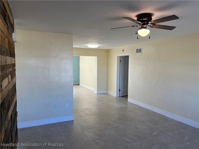 empty room featuring a fireplace and ceiling fan