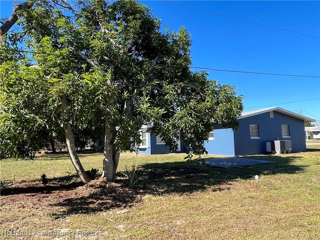 view of property exterior with cooling unit and a yard