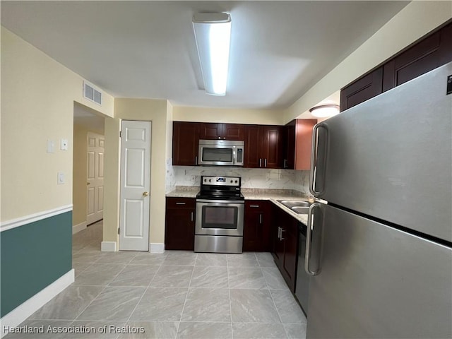 kitchen featuring sink, light tile patterned floors, backsplash, and appliances with stainless steel finishes