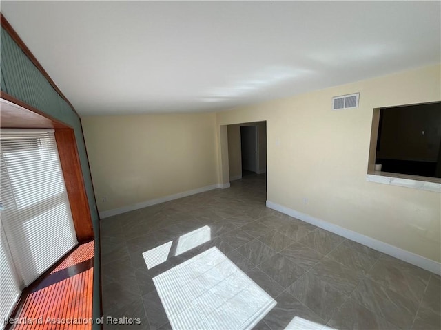 unfurnished room with lofted ceiling