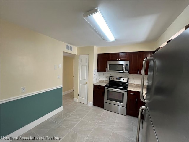 kitchen with tasteful backsplash and appliances with stainless steel finishes