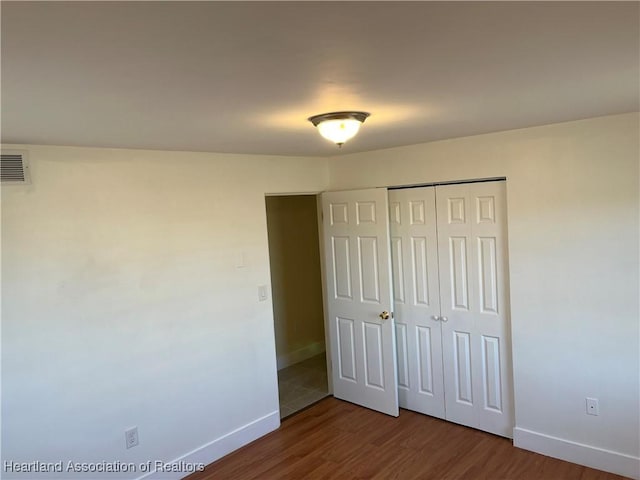 unfurnished bedroom with hardwood / wood-style floors and a closet