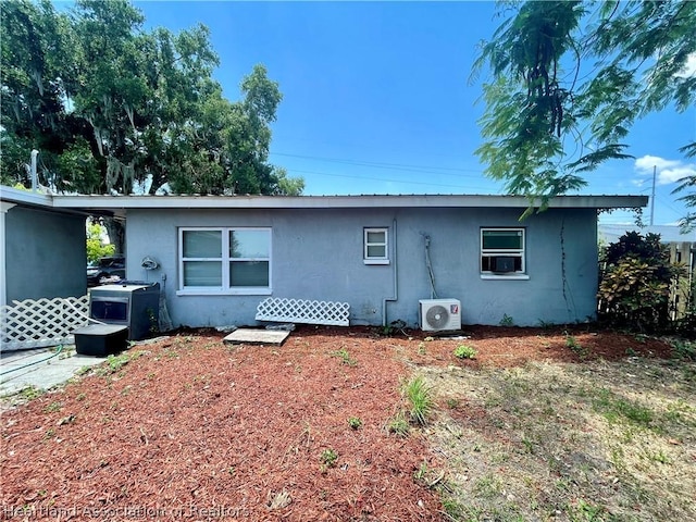 back of house featuring ac unit and a carport