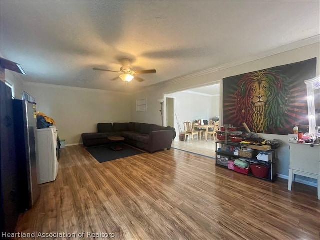 living room with hardwood / wood-style flooring, ceiling fan, and ornamental molding