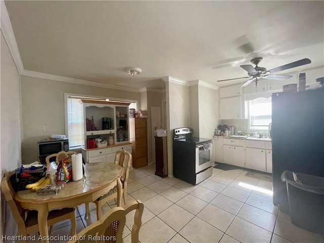 kitchen with appliances with stainless steel finishes, ornamental molding, ceiling fan, light tile patterned floors, and white cabinetry