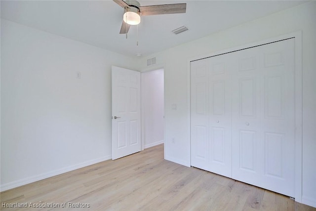 unfurnished bedroom with ceiling fan, a closet, and light hardwood / wood-style flooring