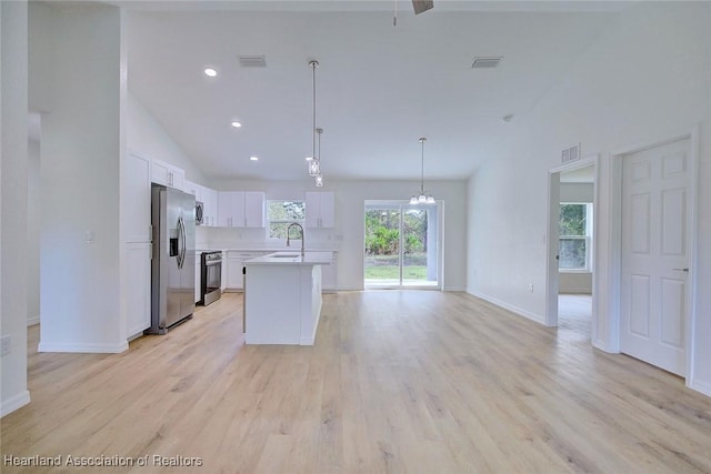 kitchen featuring white cabinetry, sink, stainless steel appliances, light hardwood / wood-style flooring, and pendant lighting