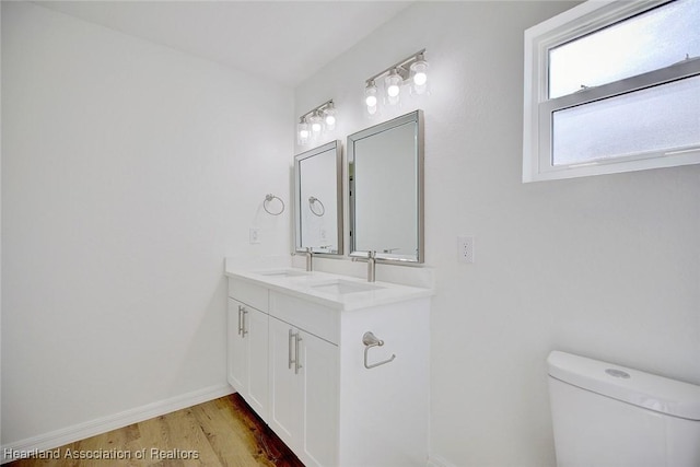 bathroom with hardwood / wood-style floors, vanity, and toilet